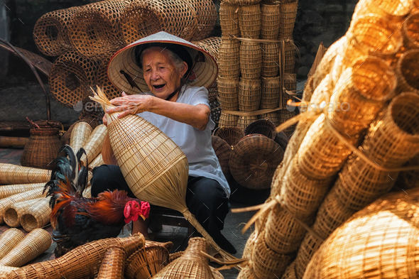 Old Vietnamese female craftsman making the traditional bamboo fish trap or  weave Stock Photo by thananit_s