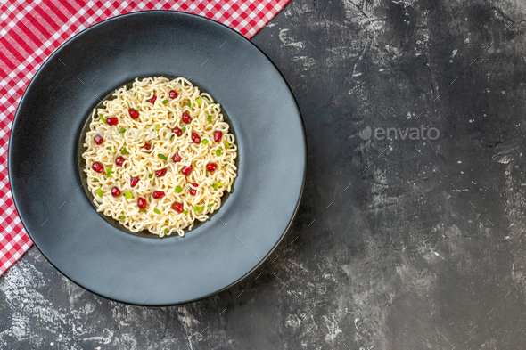 top view ramen noodles on dark round plate red and white checkered tablecloth on dark table with