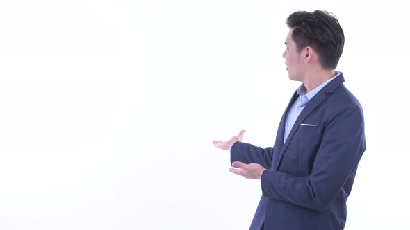 Happy Young Asian Businessman Showing To the Back alt
