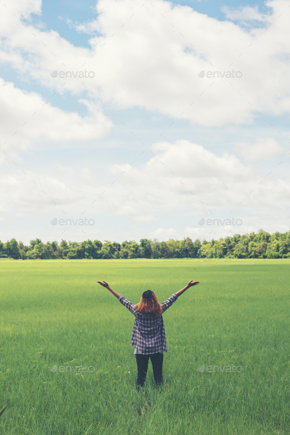 Young beautiful woman stretching her arms into the sky enjoy and happy with  fresh air at grassland. Stock Photo by Johnstocker