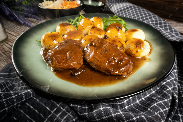 Traditional German braised pork cheeks in brown sauce.