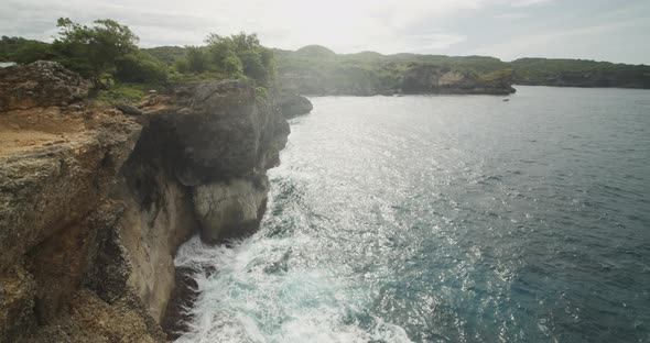 Tilting View of the Steep Sea Cliffs and Rough Waves Crashing Ashore Below in Beautiful Broken Beach alt