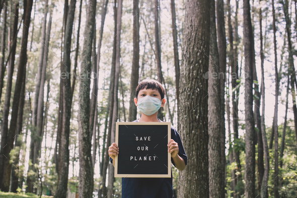 Boy in the forest doing Save Our Planet campaign