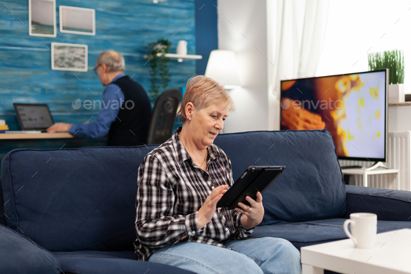 Happy mature woman relaxing on couch