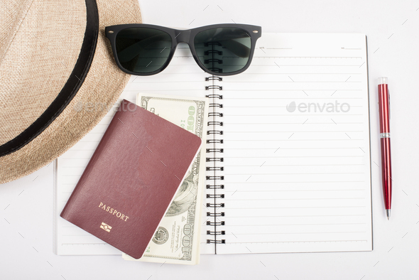 Passports,hat, camera ,glasses, pen on a paper floor ready to travel.