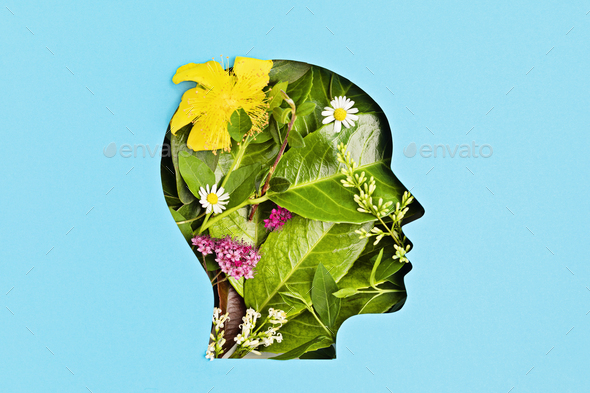 Papercut head with green leaves and flowers. Mental health, emotional wellness, contented emotions