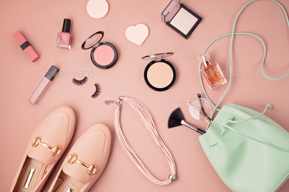 Flat lay of female fashion accessories, makeup products and