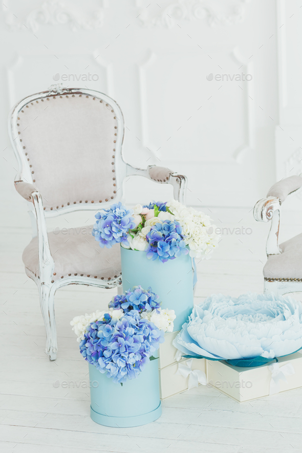 Light vintage style armchair and boxes of flowers
