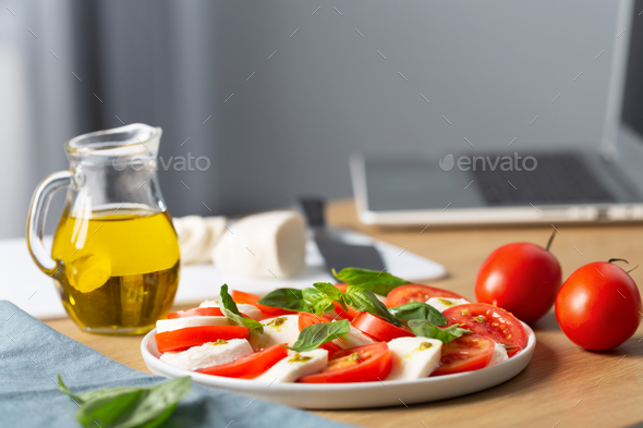 Home cooking concept. Caprese salad. Italian famous salad with fresh tomatoes, mozzarella cheese