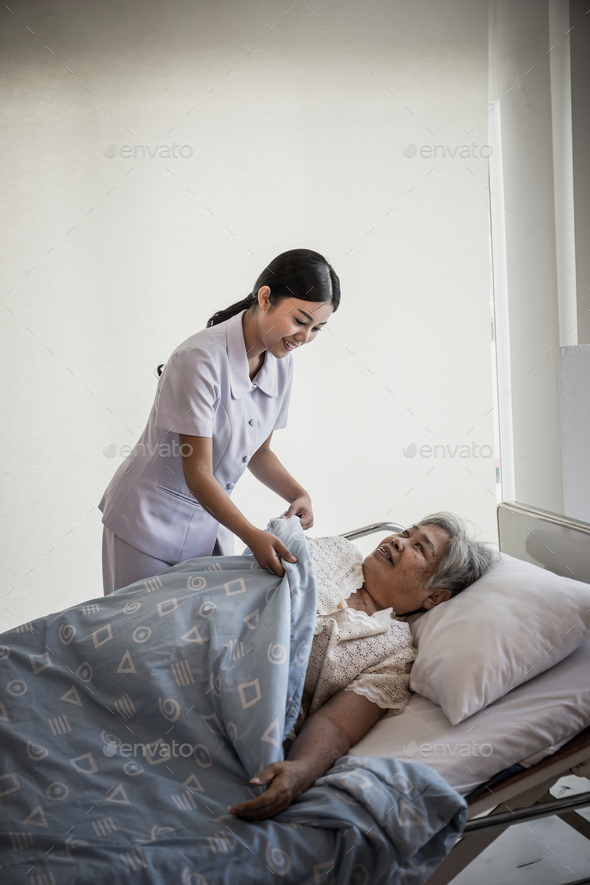 Young Nurse take care for elderly patients during hospital admission. - Stock Photo - Images