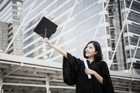 Portrait of young female graduates in square academic cap smiling happy holding diploma.