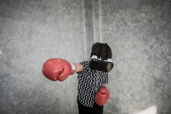 Little Boy in virtual reality glasses playing the boxing game. - Stock Photo - Images