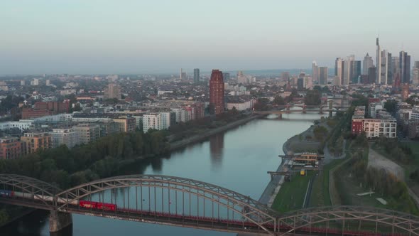 Empty Cargo Train Going Over Bridge on Main River in Frankfurt Am Main with Skyscraper Skyline View alt