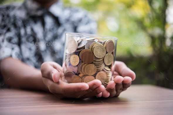 Hand  putting coins in jar with money stack step growing growth saving money - Stock Photo - Images