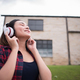 Young woman listening to music with mobile phone outdoor. Happy smiling girl listening to music. - PhotoDune Item for Sale
