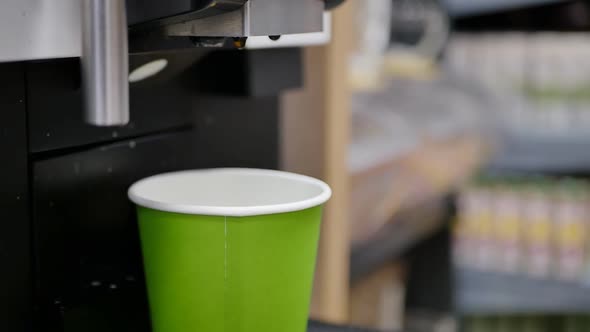 the Woman's Hand Placed a Green Glass in the Coffee Machine and Turned It on