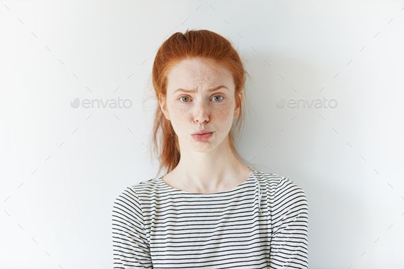 Headshot of grumpy or annoyed female employee or customer, expressing suspicion and sadness. Student