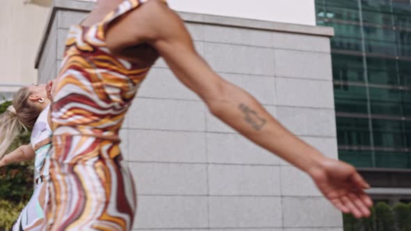 Fashion Models Dancing Together In Brightly Coloured Clothing alt