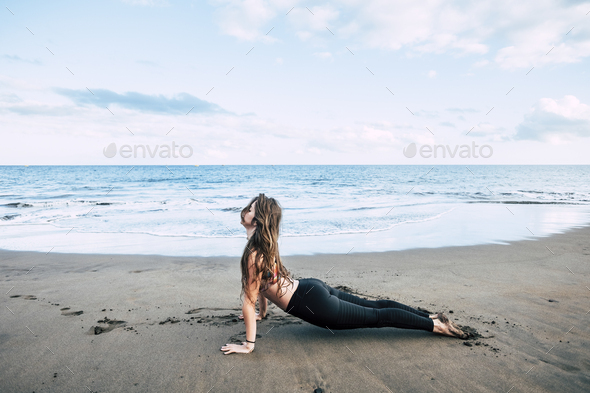 Plank fitness position at the beach with beautiful brunette girl enjoying a helthy sport lifestyle