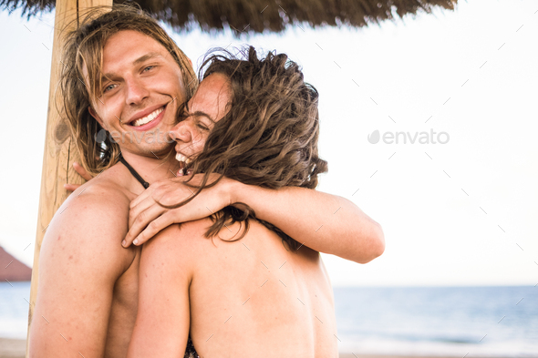 Handsome and attractive young man and woman hugging and enjoying the relationship in summer
