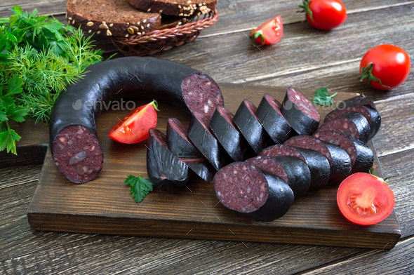 Morsilla - blood sausage. Pieces of Spanish black pudding on a wooden cutting board. Easter menu.