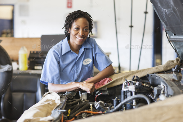 Portrait of smiling black female mechanic in auto repair shop