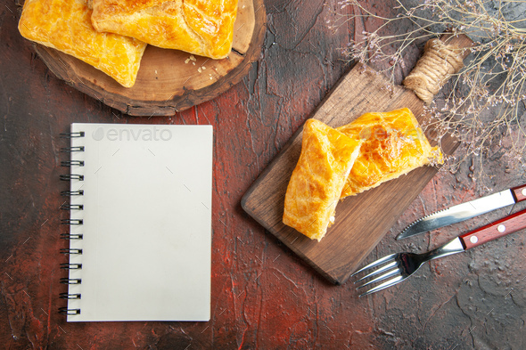 top view penovani khachapuri on wood board and on chopping board knife and fork a notebook on dark - Stock Photo - Images