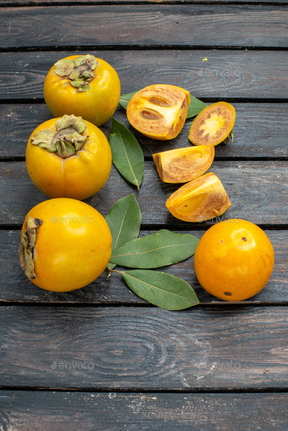 front view fresh sweet persimmons on a wooden rustic desk fruit ripe mellow tree