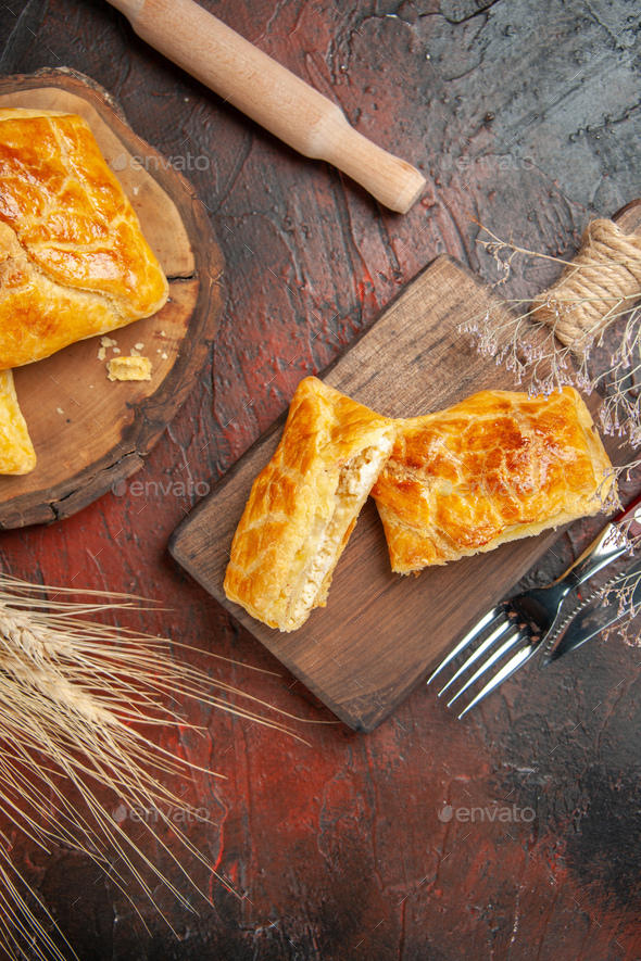 top view penovani khachapuri on wood board and on chopping board knife and fork rolling-pin on dark - Stock Photo - Images