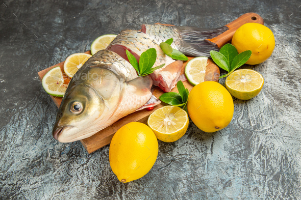 front view sliced fresh fish with lemon on light background ocean raw  seafood Stock Photo by AydinovKamran