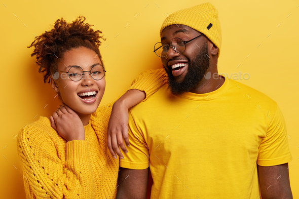 Photo of delighted cheerful young Afro American woman and man smile broadly, satisfied with good res