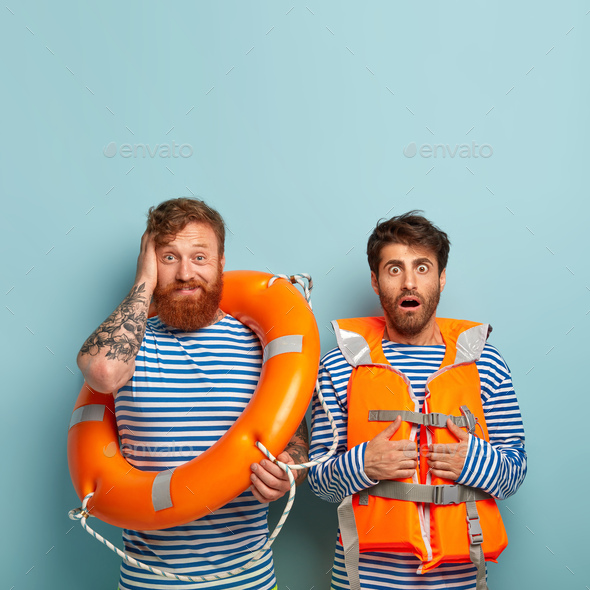 Horrified male insructor in lifejacket and his trainee, wears sailor clothes, have swimming lessons