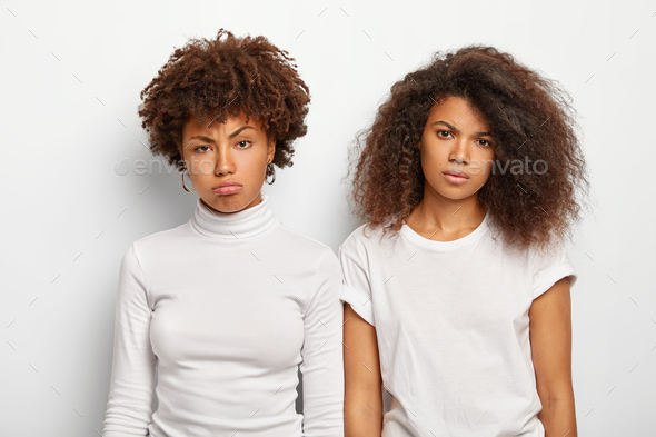 Unhappy bored women with curly hair, have displeased faces, feel embarrassed, being in low spirit, d