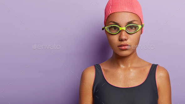 Cropped shot of female swimming coach has serious look, gives lessons of professional swim to traine