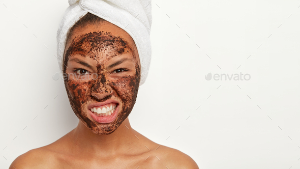 Photo of displeased female model smirks face, being dissatisfied with something, has coffee scrub ma
