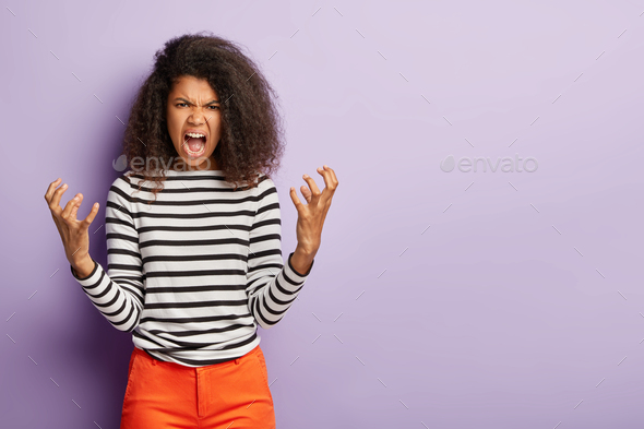Dont bother me! Outraged Afro woman gestures angrily and screams at someone, has quarrel with boss,
