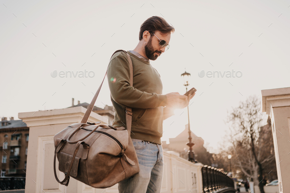 hipster man walking in street with bag