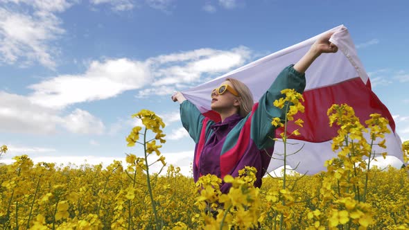 Woman with Belarus flag in yellow rapeseed field