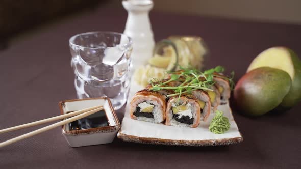 The camera moves away from the sushi set beautifully decorated on a plate alt