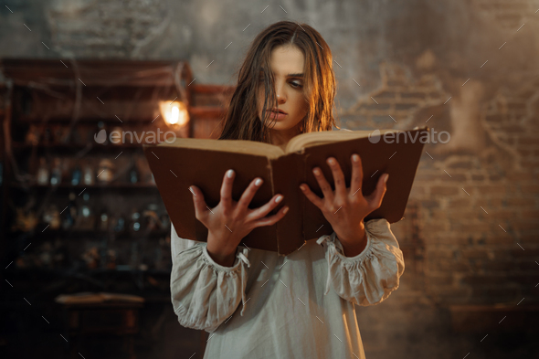 Young demonic woman holds book of spells