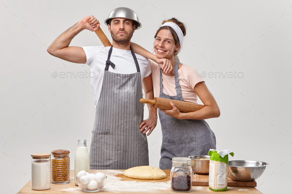 Time to cook. Friendly cook team make dough, hold wooden rolling pins, feel tired but satisfied, pos