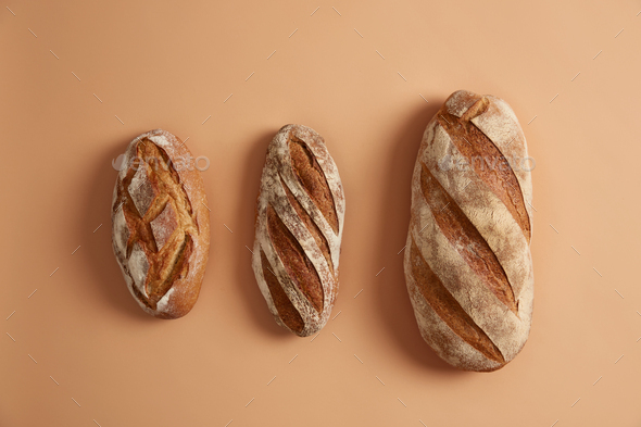 Three tasty loaves of bread arranged on beige background. Gluten free homemade bakery products. Orga