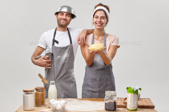Talented young woman cook achieves much in culinary sphere, holds prepared raw dough, tries new reci - Stock Photo - Images