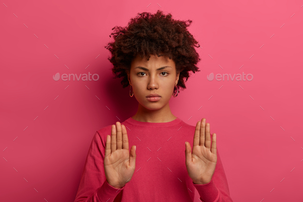No means never. Strict serious looking woman pulls palms forward at camera in no gesture, rejects of