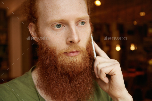 Headshot of sad and upset man calling his girlfriend to tell her that he is late. Handsome guy speak