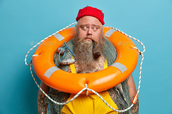 Thoughtful mariner carries inflated ring buoy on neck, ready to rescue ...