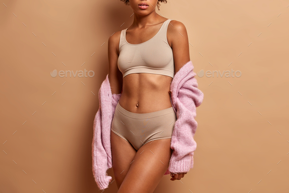 Unrecognizable slim young woman in lingerie has slim figure healthy skin  perfect body shape poses ag Stock Photo by wayhomestudioo