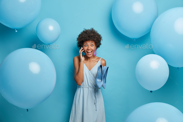Beautiful winsome joyous woman organizes and prepares party event, invites friends via smart phone,