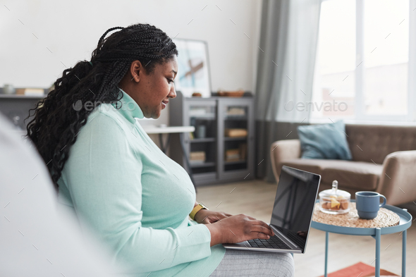 Overweight African American Woman Using Laptop Side View