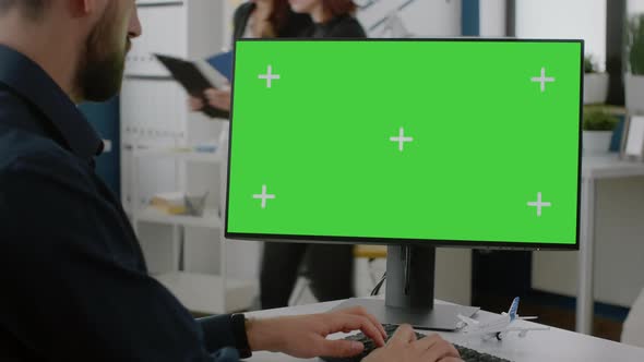 Close Up of Man Typing on Keyboard with Green Screen on Monitor alt